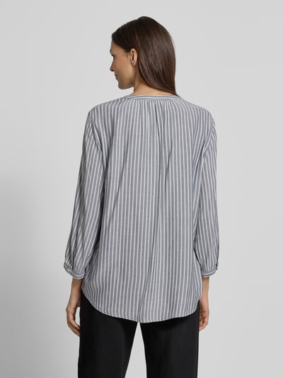 Modelka nosi Comfort Fit Langarmbluse aus reiner Viskose von Tom Tailor, szaro-białe paski, 3/4 rękaw, materiał wiskozowy, widok całej sylwetki z tyłu.