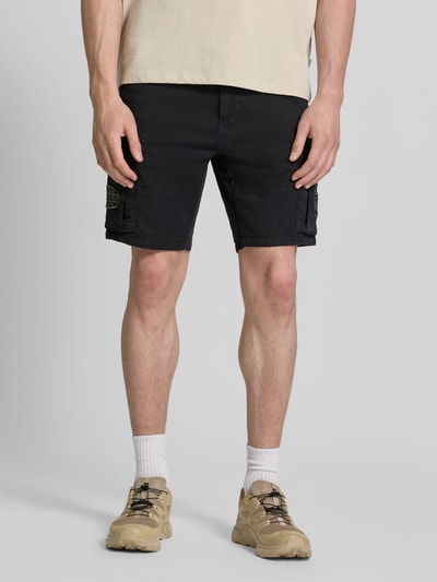 Männermodel trägt Regular Fit Bermudas mit Cargotaschen von Petrol, schwarz, Baumwoll-Mix mit Stretch-Anteil, Eingrifftaschen, Ganzkörperansicht von vorne.