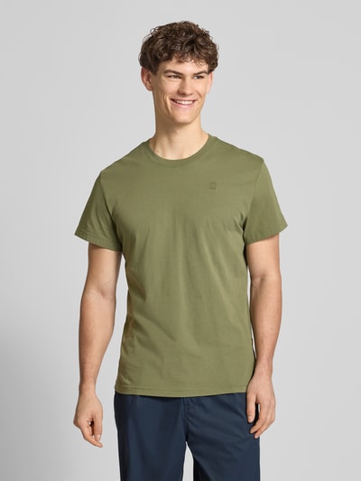 Mannelijk model draagt T-Shirt aus Baumwolle van G-Star Raw in olijfgroen, rechte fit, ronde hals, label-stiksel, vooraanzicht volledige lichaamsopname.