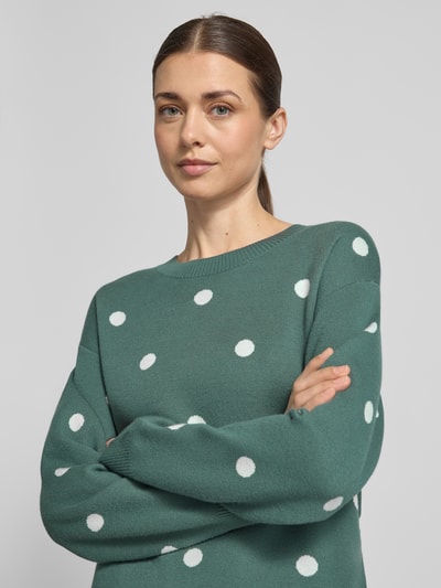 Frauenmodel trägt Strickpullover aus Viskose-Mix Modell 'Flow' von FREE/QUENT in Grün mit weißen Punkten, Rundhalsausschnitt, Nahaufnahme Oberkörper.
