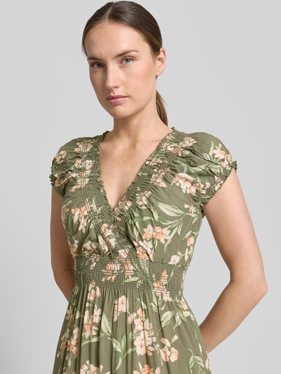 Modelka kobieca nosi Maxikleid aus Viskose mit V-Ausschnitt od Apricot, zieleń z kwiatowym wzorem, krój A-linii, Szerokość w rozmiarze S: 39 cm, czysta wiskoza, dekolt V, długość tyłu S: 136 cm, ujęcie: zbliżenie górnej części ciała.