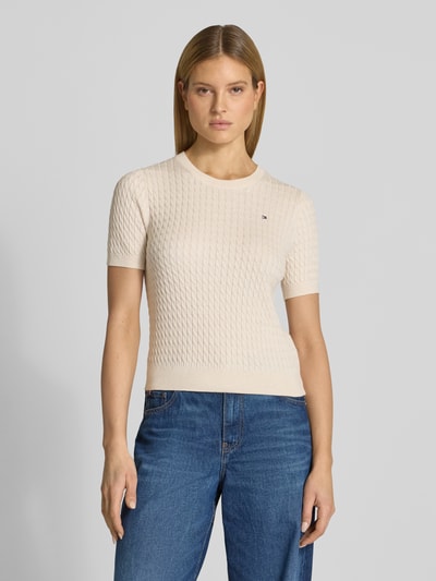 Frauenmodel trägt Slim Fit T-Shirt aus reiner Baumwolle von Tommy Hilfiger, unifarben, Zopfmuster, Rundhals, Nahaufnahme Oberkörper.