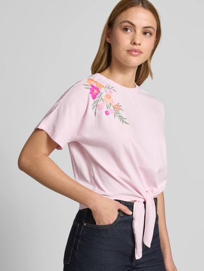 Frauenmodel trägt Damen T-Shirt von YAS, Regular-Fit, Reine Baumwolle, florales Stitching, Zierknoten, Modell 'Fabian', Nahaufnahme Oberkörper.