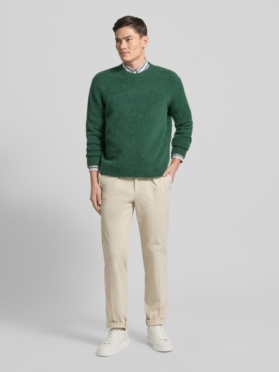 Männermodel trägt Relaxed Fit Hose mit Bügelfalten von Profuomo aus Baumwoll-Elasthan-Mix in Beige, Gesäßtaschen, Ganzkörperansicht von vorne.