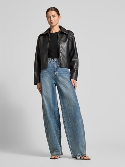 Frauenmodel trägt Slim Fit Langarmshirt mit Strasssteinen von Armani Exchange, schwarze Strick-Optik, Ganzkörperansicht von vorne.