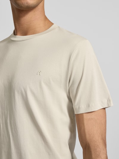 Männermodel trägt Regular Fit T-Shirt mit Logo-Detail von Replay, Reine Baumwolle, Rundhalsausschnitt, helle Farbe, Nahaufnahme Oberkörper.