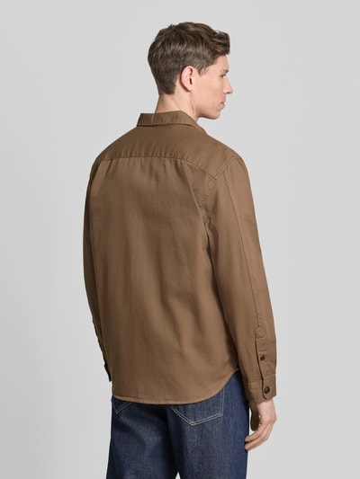 Męski model nosi Regular Fit Hemdjacke aus Bio-Baumwoll-Mix Modell 'TRAVIS' od SELECTED HOMME, brązowy twill, krój regular fit, gładki materiał, tył, długie rękawy, kieszenie na piersi, zdjęcie całej sylwetki od tyłu.