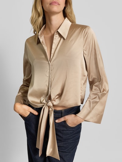 Frauenmodel trägt Regular Fit Langarmbluse mit Hemdblusenkragen Modell 'ERRIKA' von HUGO, Optik: Unifarben, Materialverarbeitung: Satin, tiefer V-Ausschnitt, einreihige Knopfleiste, Ärmelform: Langarm, Farbton Beige, glatte Textur, Nahaufnahme Oberkörper.