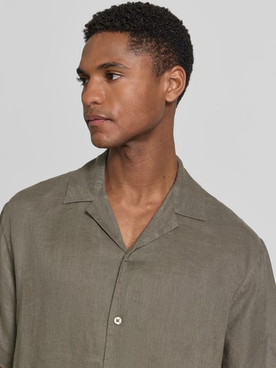 Männermodel trägt Regular Fit Leinenhemd Modell 'LAWRENCE' von Jack & Jones Premium in Oliv mit Reverskragen, Nahaufnahme Oberkörper.