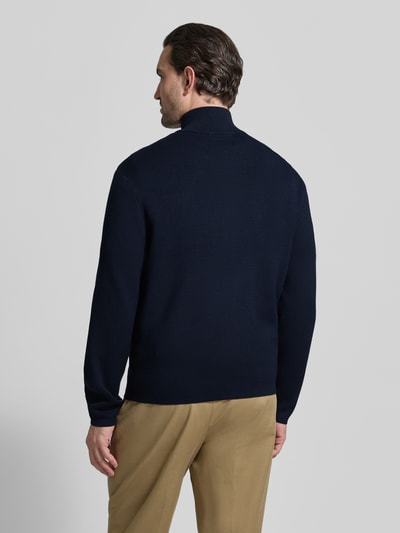 Männermodel trägt Relaxed Fit Strickjacke aus Viskose-Mix Modell 'TELLER' von SELECTED HOMME, navy, Feinstrick, Ganzkörperansicht Rückansicht.