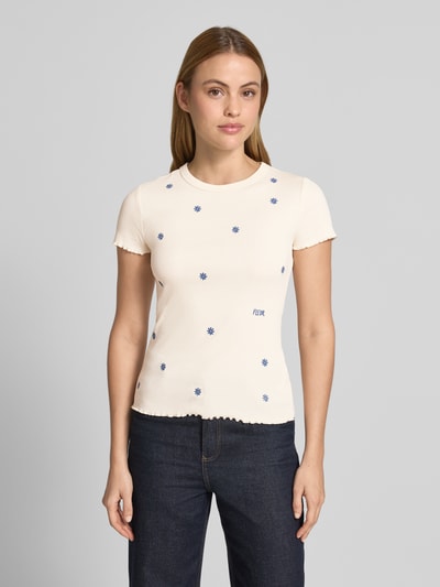 Modelka kobieca nosi T-Shirt in Ripp-Optik mit Stitchings od Jake*s Casual, kremowy kolor, krój slim fit, z bawełny organicznej z elastanem, wzór niebieskich haftów, długość tyłu w rozmiarze S: 55 cm, całkowity widok z przodu.