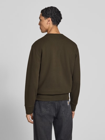 Männermodel trägt Sweatshirt aus Baumwoll-Mix von Superdry in Dunkelgrün mit elastischen Abschlüssen, lockerer Passform, Ganzkörperansicht Rückansicht.