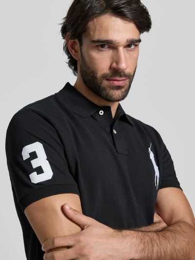 Männermodel trägt Shaped Fit Poloshirt aus reiner Baumwolle von Polo Ralph Lauren, Optik: Unifarben, Logo-Stitching, Nahaufnahme Oberkörper.