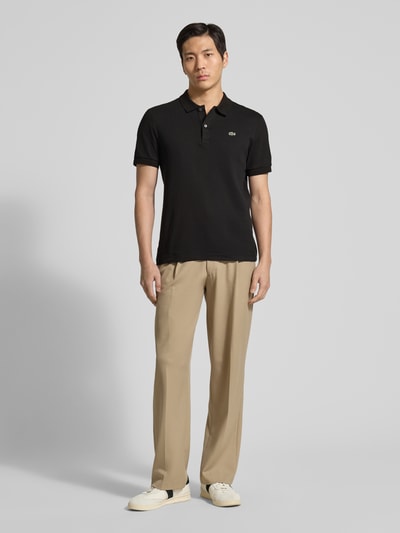 Männermodel trägt Regular Fit Poloshirt aus reiner Baumwolle von Lacoste, Optik: Unifarben, Logo-Detail, Ganzkörperansicht von vorne
