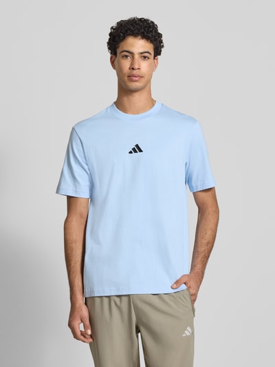 Männermodel trägt T-Shirt mit Label-Detail von adidas Sportswear in Hellblau, Regular Fit, reine Baumwolle, Nahaufnahme Oberkörper.