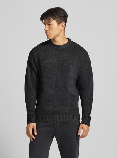 Männermodel trägt Strickpullover mit Rundhalsausschnitt Modell 'SOHO OLLIE' von JACK & JONES, Woll-Materialmix, Regular Fit, Ganzkörperansicht von vorne.