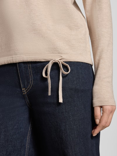 Frauenmodel trägt Strickpullover in Ripp-Optik mit Rundhalsausschnitt von Christian Berg Woman, tailliert, cremefarben, mit Tunnelzug im Bund, Nahaufnahme Oberkörper.