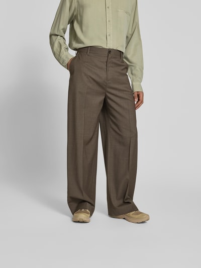 Mannenmodel draagt Wide Fit Stoffhose aus Woll-Mix van Filippa K in bruin, elastische wolmix, wide fit, vouwplooien, achterzakken, knoop- en ritssluiting, binnenbeenlengte 45 cm, taillewijdte 80 cm; vooraanzicht op volledige lengte.