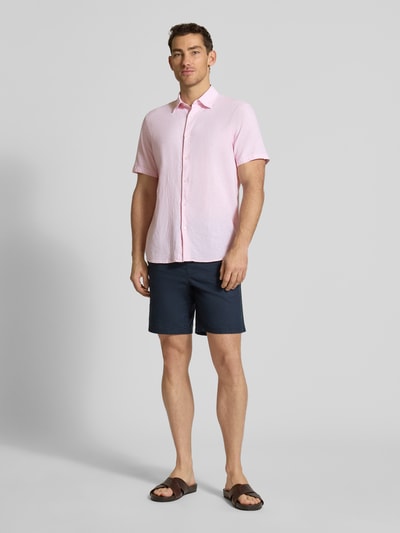 Männermodel trägt Regular Fit Freizeithemd aus Leinen-Baumwoll-Mix von MCNEAL in Rosa mit Kentkragen und Knopfleiste, Ganzkörperansicht von vorne. Rückenlänge bei Größe M: 74 cm, Schulterbreite: 50 cm, Ärmellänge: 25 cm.