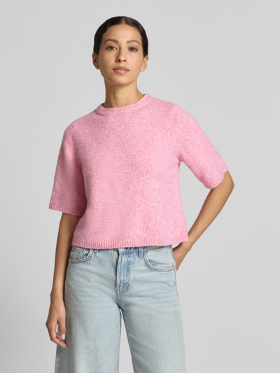 Kobieta modelka nosi różowy sweter oversized z dodatkiem wełny, model 'BOOM' od VERO MODA, damski sweter, całkowity widok z przodu.