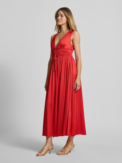 Frauenmodel trägt Maxikleid mit tiefem V-Ausschnitt Modell 'Marja' von mbyM in leuchtendem Rot, taillierter Schnitt, fließender Stoff, Material-Mix mit Viskose-Anteil, Schnürung vorn, Ganzkörperansicht von vorne.