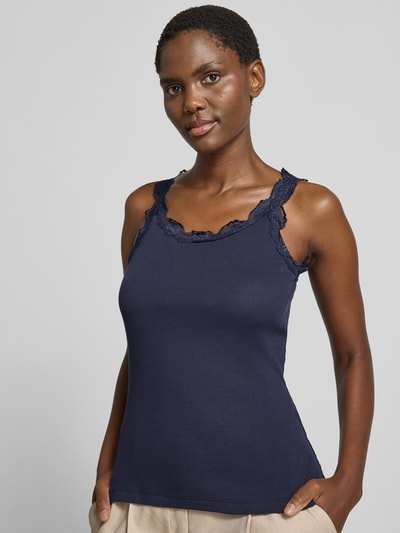 Vrouwenmodel draagt Slim Fit Top met Spitzenbesatz aus reiner Baumwolle van Rich & Royal in donkerblauw, puur katoen, slim fit, met kant en ronde hals, ruglengte maat S 56 cm, close-up bovenlichaam vooraanzicht.