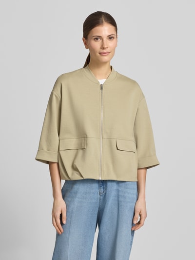 Vrouwenmodel draagt Blouson met rits en klepzakken model 'Goros' van OPUS, katoenmix met stretch, relaxed fit, 3/4-mouw, staande kraag, lichtbeige tint, gladde textuur, vooraanzicht van het volledige bovenlichaam.