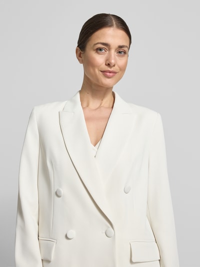 Frauenmodel trägt Regular Fit Blazer mit Pattentaschen von Christian Berg Cocktail, weißer Zweireiher im Material-Mix mit Stretch-Anteil, Nahaufnahme Oberkörper.