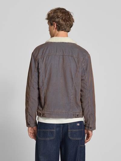 Männermodel trägt Relaxed Fit Jeansjacke aus Baumwoll-Mix von Levi's®, braune Töne, sichtbare Nähte, Ganzkörperansicht Rückansicht.