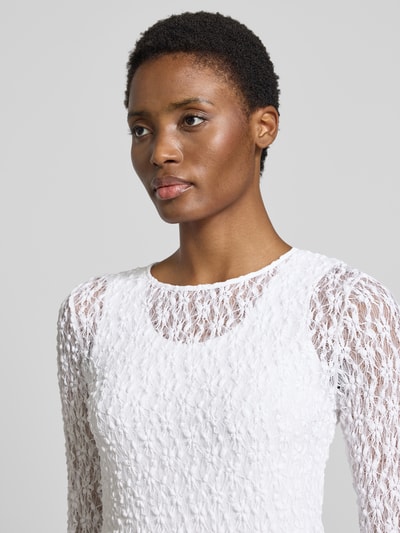 Vrouwenmodel draagt Slim Fit Longsleeve met floralem Allover-Detail van Rich & Royal in wit, semi-transparant design, elastische materiaalmix, ronde hals, dames shirt met lange mouwen, ruglengte bij maat S 56 cm, Nahaufnahme bovenlichaam.