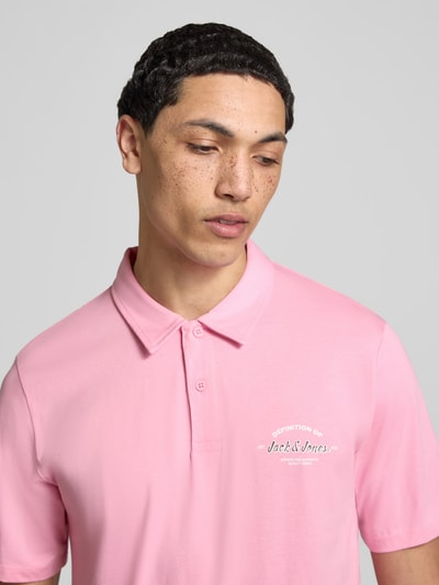 Männermodel trägt Poloshirt mit Label-Print Modell 'BRANDON' von Jack & Jones in Rosa, Reine Baumwolle, Regular-Fit, Nahaufnahme Oberkörper.