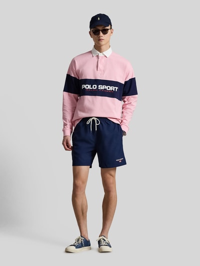 Männermodel trägt Badeshorts mit Label Stitching von Polo Ralph Lauren, unifarben, Tunnelzug, elastischer Bund, Taschen, Ganzkörperansicht von vorne.