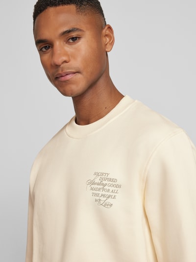 Männermodel trägt Sweatshirt mit rückseitigem Motiv-Print Modell 'Ben Faience' von Les Deux aus reiner Baumwolle, Loose Fit, Rundhals, Nahaufnahme Oberkörper.