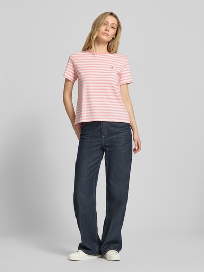 Frauenmodel trägt T-Shirt mit Rundhalsausschnitt und Label-Stitching von Gant, Damen T-Shirt aus Reine Baumwolle, Regular-Fit, rosa-weiß gestreift, Rückenlänge bei Größe S 56 cm, Ganzkörperansicht von vorne.