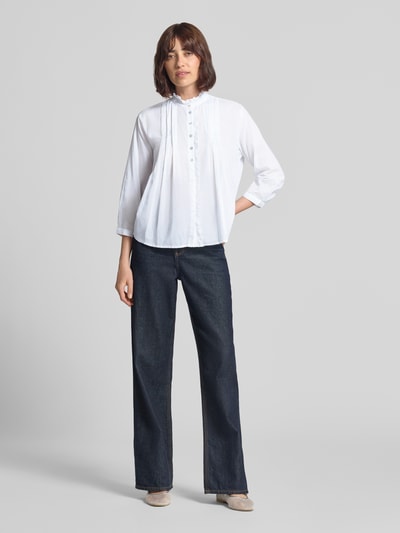 Vrouwenmodel draagt Regular Fit Blouse met Rüschenbesatz van Christian Berg Woman in puur katoen, opstaande kraag, 3/4-mouw, knoopsluiting, ruglengte maat 36: 53 cm, mouwlengte maat 36: 47 cm, wijd uitlopende jeans en lichte schoenen, kleuren wit en donkerblauw, voorkant gehele lichaam.