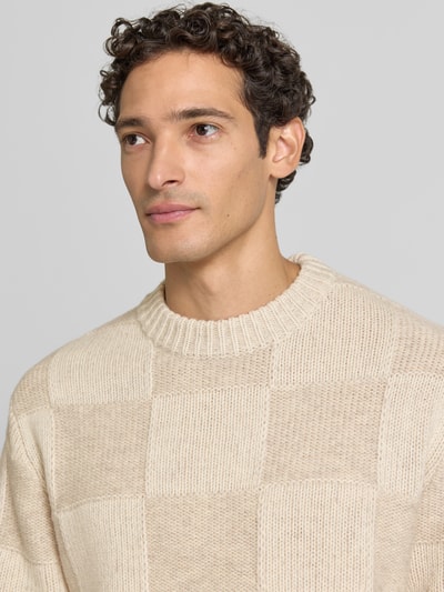 Männermodel trägt Strickpullover mit geripptem Rundhalsausschnitt von Les Deux in Beige, feine Struktur, reine Baumwolle, Nahaufnahme Oberkörper.