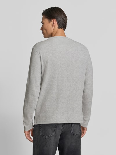 Männermodel trägt Regular Fit Longsleeve mit Waffel-Struktur von Scotch & Soda in Hellgrau, reine Baumwolle, Rückenansicht, Ganzkörperansicht Rückansicht.