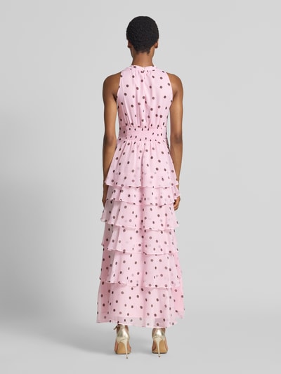 Frauenmodel trägt Abendkleid mit Rüschenbesatz Modell 'Marli' von Neo Noir in Rosa mit Punkten, tailliert, ärmellos, Ganzkörperansicht Rückansicht.