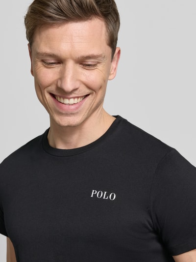 Mannenmodel draagt Regular Fit Pyjama-Oberteil aus reiner Baumwolle Modell 'CREW-SLEEP-TOP' van Polo Ralph Lauren Underwear in uni zwart met label print, logo-stitching, ronde hals en korte mouwen, materiaal katoen. Nahaufnahme bovenlichaam.