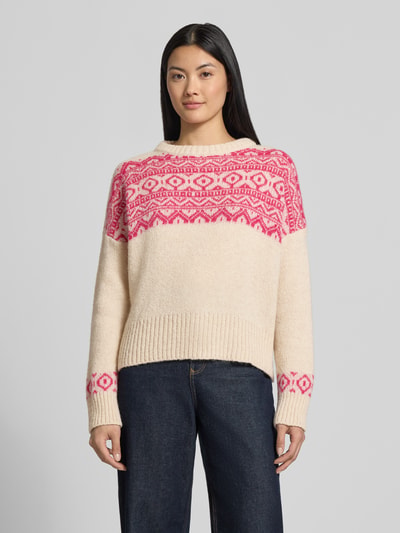 Modelka kobieca nosi kremowy Strickpullover mit Baumwoll-Anteil Modell 'Nordic' von miss goodlife z różowym wzorem, luźny krój, stójka, prążkowane wykończenia, długość tyłu w rozmiarze S: 54 cm, długość rękawa w rozmiarze S: 45 cm, widok całej sylwetki z przodu.