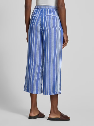 Frauenmodel trägt Culotte mit Kordelzug und Eingrifftaschen von Christian Berg Woman, gestreift in Blau und Weiß, Loose-Fit, Ganzkörperansicht Rückansicht. Bundweite bei Größe 36: 38 cm, Innenbeinlänge bei Größe 36: 60 cm, angedeutete Gesäßleistentaschen, elastischer Bund.
