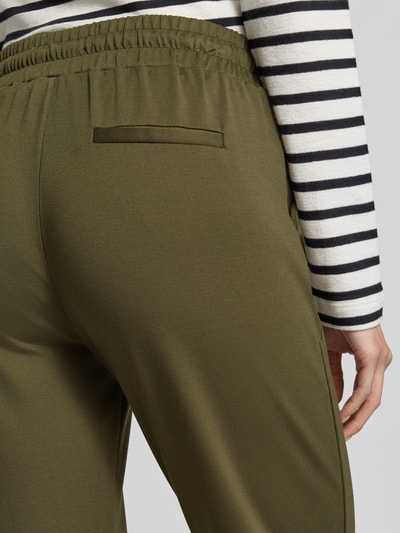 Frauenmodel trägt Sweatpants mit elastischem Bund Modell 'KATE' von ICHI in olivgrün aus Viskose-Mix, Nahaufnahme Rückansicht.