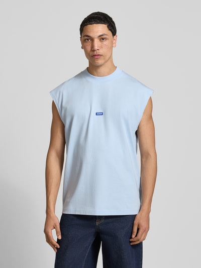 Männermodel trägt Relaxed Fit Tank Top aus reiner Baumwolle Modell 'NAVERTZ' von HUGO Blue, hellblau, unifarben, Label Patch, Nahaufnahme Oberkörper.