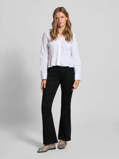 Vrouwenmodel draagt Regular Waist Bootcut-Jeans met Retro-Flare van ONLY, donker denim, flared fit, 5-pocket, knoop- en ritssluiting, geheel vooraanzicht.