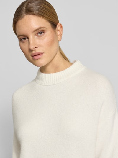 Modelka kobieca nosi Strickshirt mit überschnittenen Schultern Modell 'Pafinna' od OPUS, kremowy materiał z domieszką moheru, prążkowany dekolt, mieszanka tekstur; kontekst: prosty krój, prążkowane wykończenia, długość tyłu 53 cm, długość rękawa 25 cm; zbliżenie na górę ciała