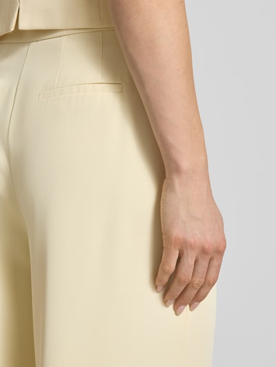 Frauenmodel trägt Wide Leg Stoffhose mit Raffungen von Christian Berg Cocktail in Creme, gefertigt aus Elastischer-Material-Mix, Detailaufnahme Rückansicht. Bundweite 38 cm, Innenbeinlänge 82 cm, Haken- und Reißverschluss.