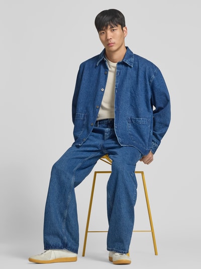 Männermodel trägt Straight Fit Jeans mit Logo-Detail von WON HUNDRED aus Reine Baumwolle in klassischem Blau, mit Eingriffstaschen, Knopf- und Reißverschluss, sichtbar sind Bundweite 45 cm und Innenbeinlänge 78 cm, Ganzkörperansicht von vorne.