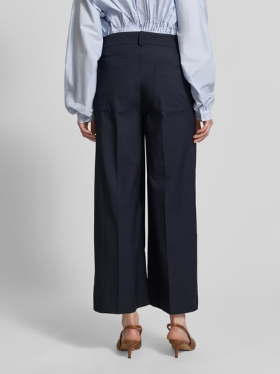 Frauenmodel trägt Stoffhose mit Eingrifftaschen Modell 'CARA' von Cambio, dunkelblau, weites Bein, Bügelfalte, Ganzkörperansicht Rückansicht.