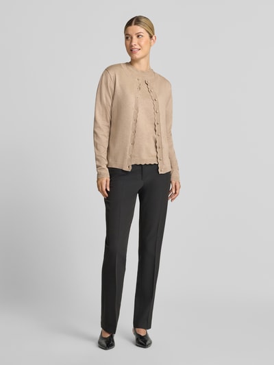 Frauenmodel trägt Strickjacke aus Viskose-Mix Modell 'MORLA' von b.young in Beige mit Muschelsaum und elastischen Ärmelabschlüssen, gerader Schnitt, schwarze Hose, Ganzkörperansicht von vorne.