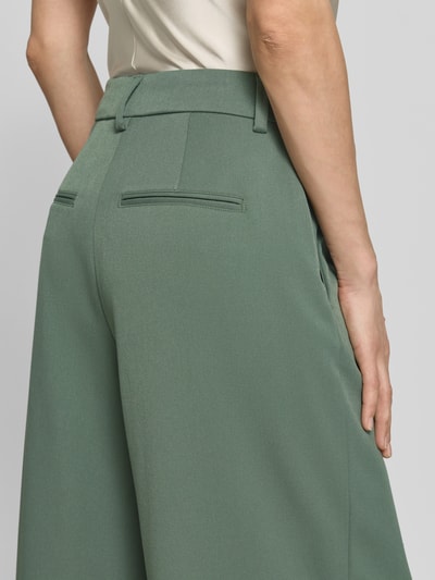 Vrouwenmodel draagt Wide Leg Pants met Biesen model 'Henrika' van MSCH Copenhagen, materiaalmix met viscose, strookzak aan de achterkant, los model, kleur groen, detailopname rugaanzicht.